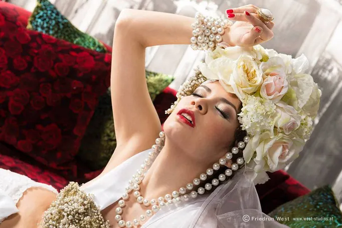 Model mit Blumenkrone, Perlenketten und roten Lippen