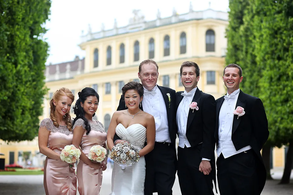 Brautpaar mit Brautjungfern und Trauzeugen vor einem Barockschloss